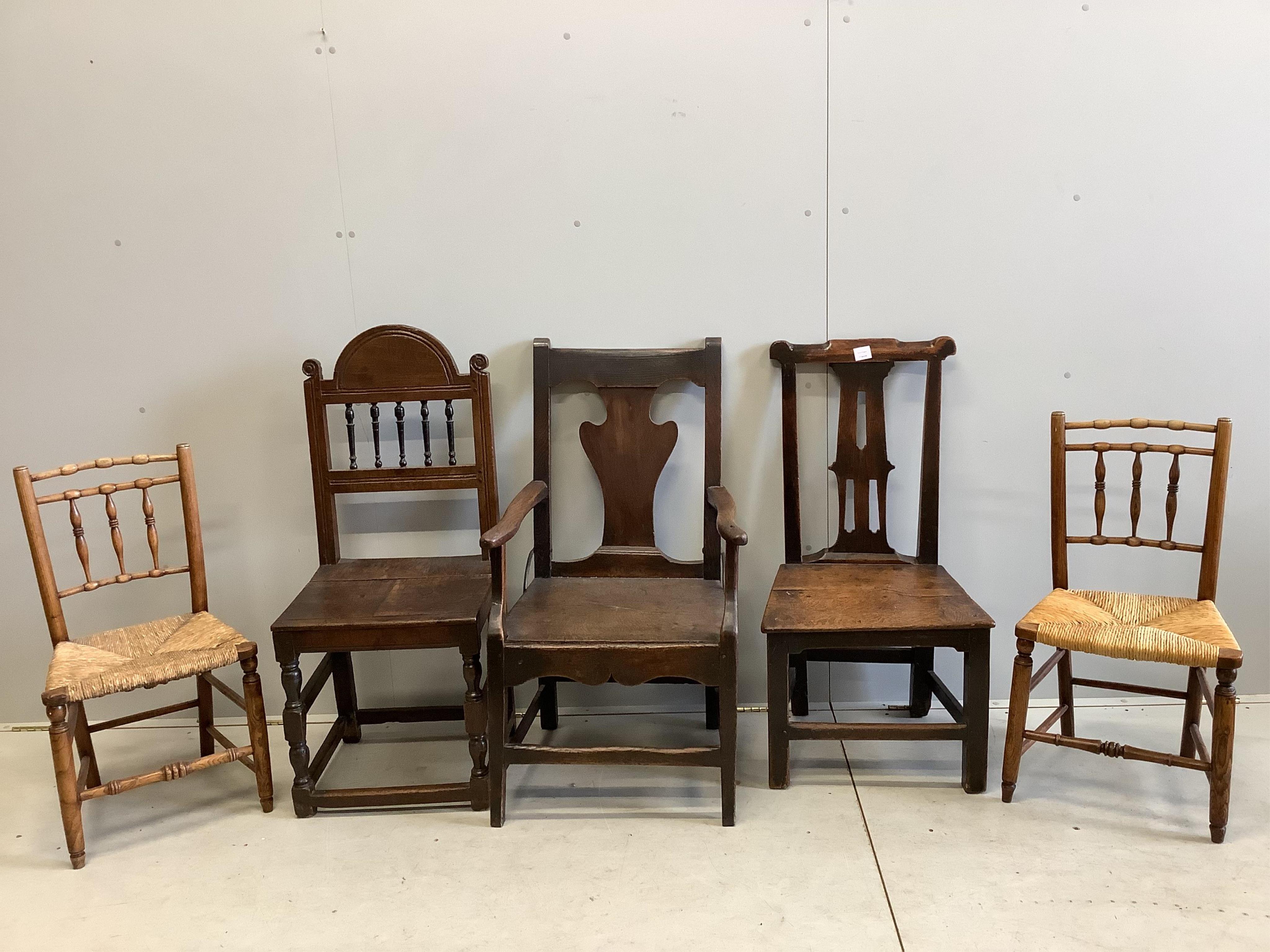 Two 18th century oak wood seat dining chairs, one with arms, a pair of rush seat chairs and one other. Condition - poor to fair